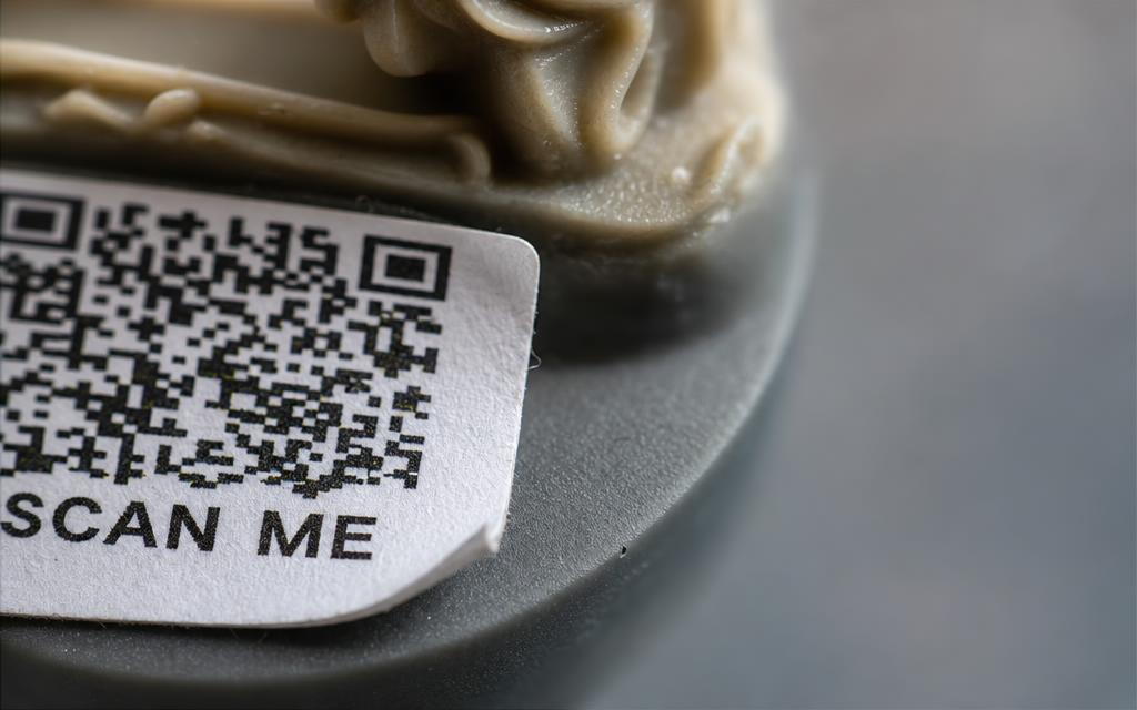 Extreme close-up of the printed SCAN ME QR label on a miniature's base
