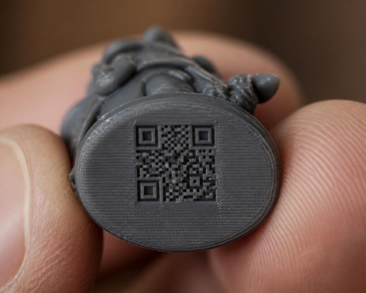 Extreme close-up of the small QR code engraved on the flat underside of a miniature